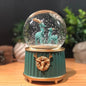 Pilli Işıklı Müzikli Kar Küresi–İki Geyikli Yeşil Figürlü Eğlenceli Masaüstü Biblo, LED Aydınlatmalı Dekoratif Hediyelik Kar Küresi